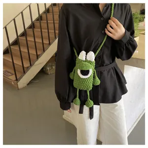 Cute green crochet monster phone bag detail, handmade knitted crossbody bag for women.