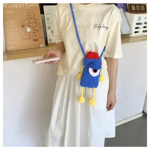 Detailed view of the cute handmade knitted contrast color mini phone bag with big eye design.