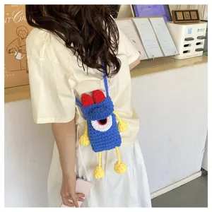 Detailed lifestyle view of the handmade crochet crossbody phone bag with cute monster design.