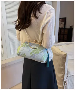 Detailaufnahme der chinesischen Blumen-Bügel-Abendtasche mit Perlenriemen und Quaste.