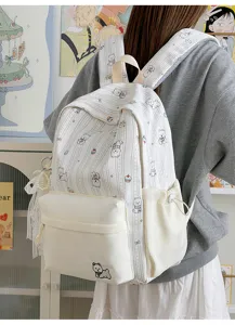Detail view of the cute dog printed backpack worn on back featuring striped fabric and side pockets.
