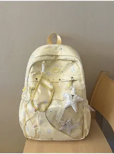 Vista dettagliata dello zaino giallo con stelle, tasca trasparente e ciondoli decorativi.