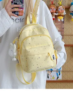 Gedetailleerd overzicht van een schattige gele mini-rugzak met sterren, casual schooltas.
