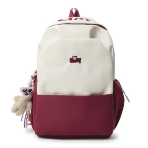 Two-tone large capacity student school bag with cute embroidered patch and plush bear charm.