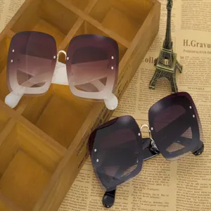 Detail shot of stylish oversized gradient sunglasses in vintage wooden box with retro decor.
