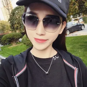 Primer plano de gafas de sol degradadas sin montura para mujer al aire libre, estilo chic.