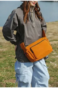 Detalle del bolso bandolera de lona para exteriores en tela naranja duradera con correa.