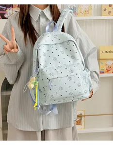 Details of light blue nylon student school backpack featuring cute star and dot prints for daily use.