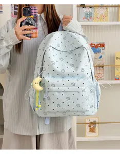 Detail view of the cute candy color nylon backpack with star pattern and moon pendant.