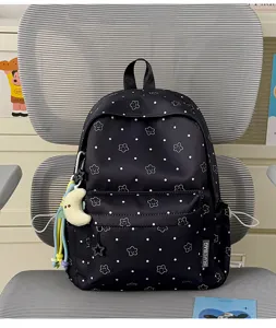 Black nylon student backpack detail, cute smiling star pattern and sweet moon pendant design.