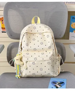 Close-up detail of the beige student backpack with cute star pattern and adorable moon pendant.