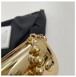 Nahaufnahme Detail der luxuriösen goldenen Abendtasche mit elegantem Perlenketten-Accessoire.