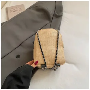 Detailed close-up view of the woven mini backpack showcasing its chain strap and texture.