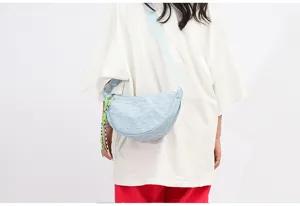 Light blue nylon crescent crossbody bag with casual strap and stylish charm for daily use.
