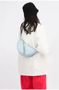 Light blue nylon crescent shoulder bag close-up, featuring stylish embossed pattern and lanyard.