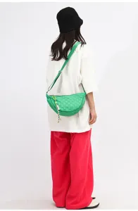 Green nylon crescent crossbody bag detail, stylish woven texture design with cute charm accessory.