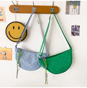 Woven nylon crescent shoulder bag, stylish casual crossbody bag with cute charm detail.
