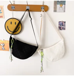 Nylon crescent shoulder bag for women, casual crossbody dumpling bag with strap and tag.
