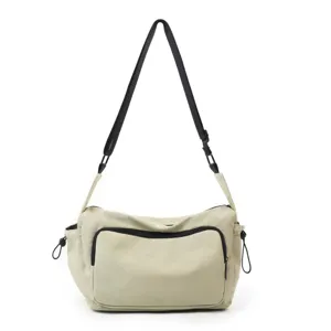 Bolso bandolera informal de nylon con correa negra ajustable y bolsillo delantero estilo utilitario.