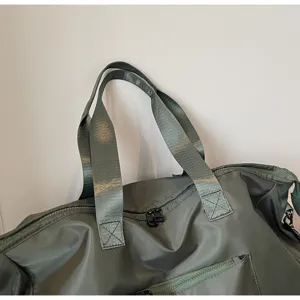 Groot detail van groene nylon reissporttas met close-up van handgrepen en ritsen.