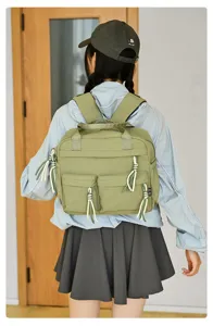 Vue detaillee du sac a dos femme en nylon vert avec multiples poches et cordons styles.