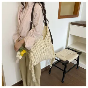 Détail du sac cabas fourre-tout tissé beige avec franges dans une scène de style de vie.