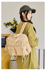 Vue détaillée du mini sac à dos décontracté en nylon kaki, avec poches et poignée.