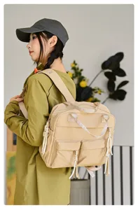 Vue détaillée du sac à dos en nylon décontracté couleur beige avec poches et glands.