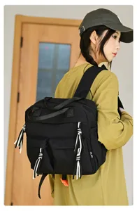 Sac à dos mini en nylon noir élégant pour femme, sac d'école décontracté avec de jolies franges.