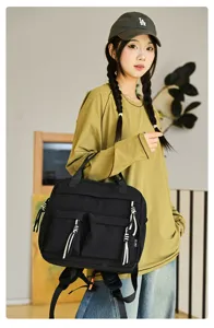 Vue détaillée d'un mini sac à dos en nylon noir de style coréen avec de beaux glands blancs.