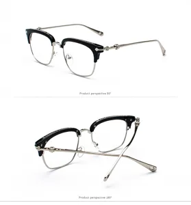 Detail view of black and silver semi-rimless glasses frame with ornate vintage carvings.