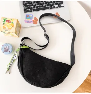 Black nylon crescent dumpling bag detail shot, casual crossbody bag with stylish strap.