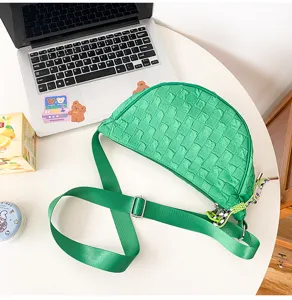 Green woven nylon crescent crossbody bag detail showcasing texture and adjustable strap.
