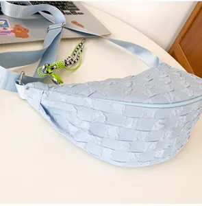 Light blue crinkled nylon crescent crossbody bag with adjustable strap and cute pendant.