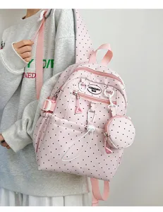 Détail de sac à dos à pois rose avec design mignon, poche avant et petite pochette assortie.