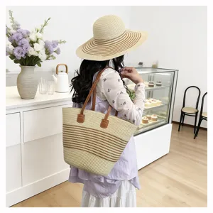 Detailed view of women woven straw tote bag with brown striped design in cafe scene.