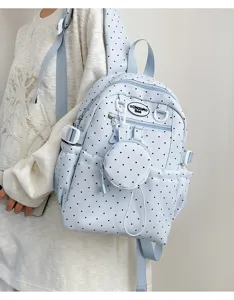 Sac à dos bleu clair à pois avec petite poche ronde pour l'école et le transport quotidien.