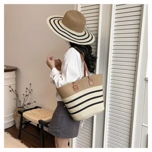 Woven straw tote bag with black stripes and brown handles. Detail shot for summer beach use.
