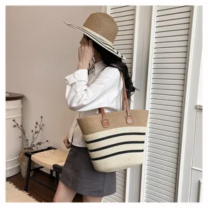 Detailed view of the stylish straw woven tote bag featuring color-block stripes and brown handles.