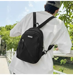 Vue detaillee du sac a dos noir en nylon porte a l'exterieur avec de belles sangles.