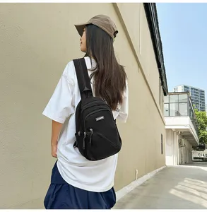 Vue détaillée d'un sac de poitrine élégant en nylon noir, porté en bandoulière casual.