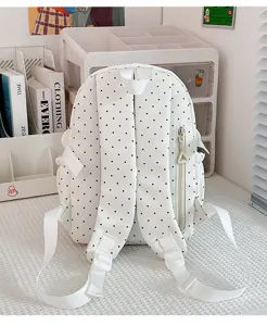 Vue détaillée du sac à dos blanc à pois mignons, avec bretelles réglables et poche latérale.