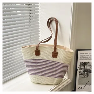 Woven straw tote bag for women, stylish striped beach shoulder bag with brown handles.