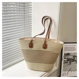 Woven straw tote bag detail, striped color-block design with brown leather shoulder straps.