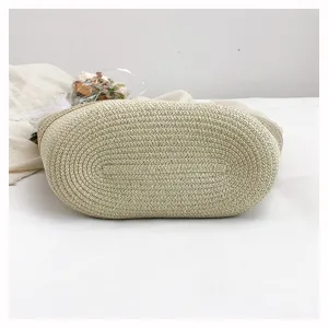 Woven straw handbag bottom detail view, casual beach vacation style, natural woven texture.