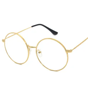 Occhiali rotondi vintage in metallo da donna con lenti trasparenti e aste finemente lavorate.