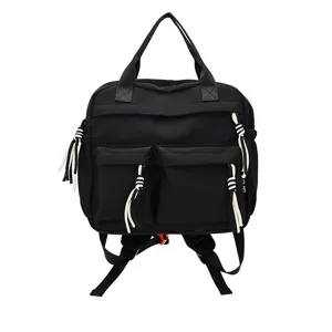 Vue detaillee de mini sac a dos en nylon noir avec poches avant et cordons blancs