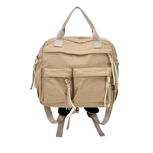 Vue détaillée de la poche avant du sac à dos en nylon kaki avec liens décoratifs blancs