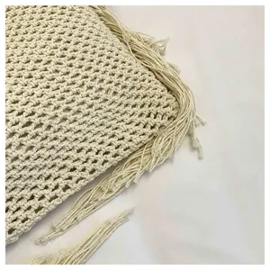 Vue détaillée du sac fourre-tout beige tissé à la main avec texture ajourée et franges.