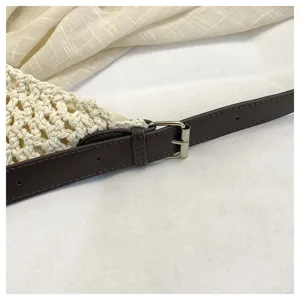 Vue détaillée du sac cabas ajouré tissé à la main avec sangle en cuir et boucle.